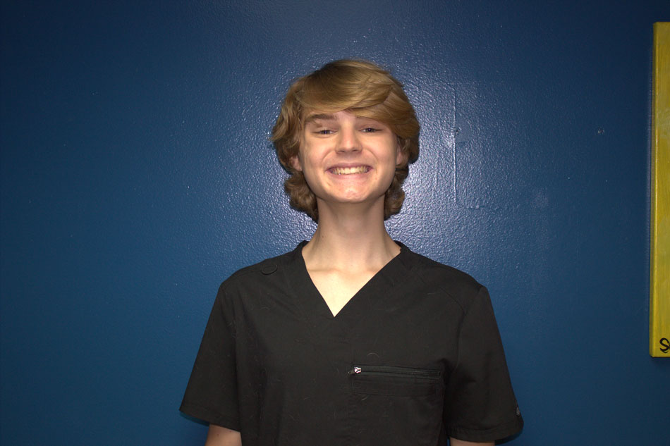 Gianni Dilalla posing in front of a dark blue wall.