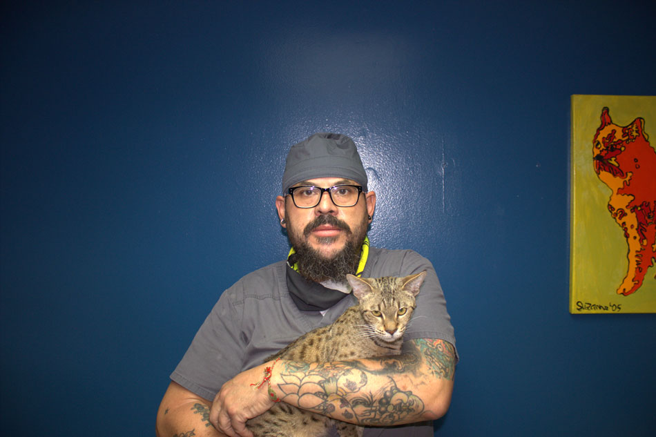 Geraldo Lopez posing with a Bengal cat.